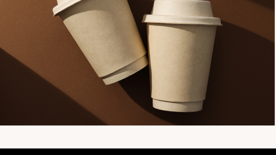 Two takeaway coffee cups on a brown background